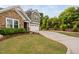 Well-manicured front lawn, a long driveway leading to the two-car garage, and mature trees offering curb appeal at 829 Churton Pl, Cary, NC 27518