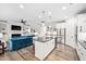Bright kitchen featuring white cabinets, stainless steel appliances, a center island, and an adjacent living room at 829 Churton Pl, Cary, NC 27518