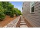 Landscaped side yard with a stone and mulch pathway and mature plantings next to a home with gray siding at 829 Churton Pl, Cary, NC 27518