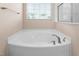 Relaxing soaking tub with chrome fixtures and a window, creating a spa-like bathroom at 839 Old Towne Dr, Elon, NC 27244