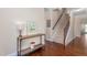Inviting foyer with hardwood floors, staircase, stylish console table, and a charming flower market poster at 839 Old Towne Dr, Elon, NC 27244