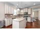 This eat-in kitchen has granite countertops, white cabinets and a decorative tile backsplash at 839 Old Towne Dr, Elon, NC 27244