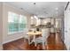 Bright eat-in kitchen features white cabinets, granite countertops, stainless appliances, and hardwood flooring at 839 Old Towne Dr, Elon, NC 27244