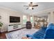 Bright living room boasts hardwood floors, plush rug, ceiling fan, and view into the bright eat-in kitchen at 839 Old Towne Dr, Elon, NC 27244