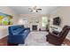 Bright living room with fireplace, hardwood floors, comfortable seating, large windows, and a ceiling fan at 839 Old Towne Dr, Elon, NC 27244