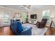Cozy living room with a fireplace, large windows, hardwood floors, comfortable seating, and a ceiling fan at 839 Old Towne Dr, Elon, NC 27244