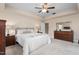 Light-filled main bedroom features a tray ceiling, ceiling fan, soft carpet, and large windows at 839 Old Towne Dr, Elon, NC 27244