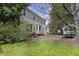 Backyard featuring a large shade tree, lush green lawn, and landscaping at 8608 Cheerful Ct, Raleigh, NC 27615
