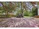 Beautiful backyard with patio, playhouse, mature trees, and blooming cherry blossoms at 8608 Cheerful Ct, Raleigh, NC 27615