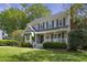 A beautiful two-story home with a front porch, dark green shutters, complemented by lush green lawns and landscaping at 8608 Cheerful Ct, Raleigh, NC 27615