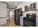 Traditional kitchen with black appliances, hardwood floors, and white cabinets offers a functional design at 8608 Cheerful Ct, Raleigh, NC 27615