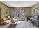 Cozy living room with piano, seating, wood trim, and backyard views offers a comfortable retreat at 8608 Cheerful Ct, Raleigh, NC 27615
