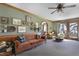 Retro living room with vintage couches, wood-trimmed green walls, and doorways to a dining room and outdoor patio at 8608 Cheerful Ct, Raleigh, NC 27615