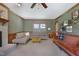 Spacious living room featuring vintage sofas, a ceiling fan, and a fireplace, with natural light from the windows at 8608 Cheerful Ct, Raleigh, NC 27615