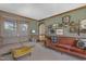 Retro living room with vintage couches, wood-trimmed green walls, windows, and doorways to a dining room at 8608 Cheerful Ct, Raleigh, NC 27615