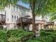 View of the home's backyard, featuring a wooden deck, brick facade, and lush green landscaping at 8722 Macedonia Lake Dr, Cary, NC 27518