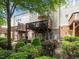 View of the home's backyard, featuring a wooden deck, small patio, and lush green landscaping at 8722 Macedonia Lake Dr, Cary, NC 27518