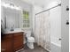 Well-lit bathroom features a vanity with a dark wood cabinet and a shower with patterned curtain at 8722 Macedonia Lake Dr, Cary, NC 27518