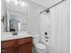 Bathroom featuring a shower with curtain, white walls, dark fixtures, and wood cabinet at 8722 Macedonia Lake Dr, Cary, NC 27518