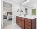 Elegant bathroom with a wood vanity and clear view into a bedroom with a calming ceiling fan at 8722 Macedonia Lake Dr, Cary, NC 27518