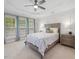 Bedroom features a large bed, dresser, tray ceiling, and bright natural light from the windows at 8722 Macedonia Lake Dr, Cary, NC 27518