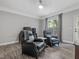 This cozy bedroom has 2 recliner chairs, wood floors, and a beautiful window view at 8722 Macedonia Lake Dr, Cary, NC 27518