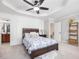 Cozy bedroom featuring a decorative tray ceiling, ceiling fan, and neutral color palette at 8722 Macedonia Lake Dr, Cary, NC 27518