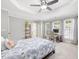 Bedroom featuring a ceiling fan, tray ceiling, windows, and a computer desk at 8722 Macedonia Lake Dr, Cary, NC 27518
