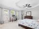 Sunlit bedroom featuring a tray ceiling, a ceiling fan, and a cozy workspace near the windows at 8722 Macedonia Lake Dr, Cary, NC 27518