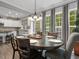 Dining room open to the kitchen features a large table, chandelier, and views of the outdoor scenery at 8722 Macedonia Lake Dr, Cary, NC 27518