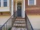 Inviting front entrance with a charming wreath, 'Home Sweet Home' sign, and brick stairs at 8722 Macedonia Lake Dr, Cary, NC 27518