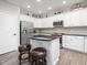 Bright kitchen featuring white cabinets, stainless steel appliances, and a center island with bar stool seating at 8722 Macedonia Lake Dr, Cary, NC 27518