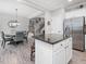 Bright kitchen island with stainless steel refrigerator and view of dining area and staircase at 8722 Macedonia Lake Dr, Cary, NC 27518