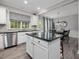 Open concept kitchen with stainless steel appliances, center island, and a view into the adjacent dining area at 8722 Macedonia Lake Dr, Cary, NC 27518