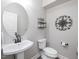 Elegant powder room featuring a sleek pedestal sink, decorative mirror, and stylish wall accents at 8722 Macedonia Lake Dr, Cary, NC 27518