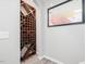 Wine cellar with an arched shelf for bottles, neutral colors, and table of varietals art at 8722 Macedonia Lake Dr, Cary, NC 27518