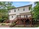 Two-story home featuring a wooden deck, brick foundation, and stone terrace overlooking the manicured lawn at 912 Salem Woods Dr, Raleigh, NC 27615