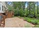 Backyard featuring a lush green lawn, stone terrace, and colorful flowering shrubs at 912 Salem Woods Dr, Raleigh, NC 27615