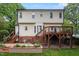 Two-story home featuring a wooden deck, brick foundation, and stone terrace overlooking the manicured lawn at 912 Salem Woods Dr, Raleigh, NC 27615