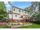Two-story home featuring a wooden deck, brick foundation, and stone terrace overlooking the manicured lawn at 912 Salem Woods Dr, Raleigh, NC 27615