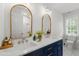 Elegant bathroom with dual sinks, white cabinets, and stylish gold framed mirrors at 912 Salem Woods Dr, Raleigh, NC 27615