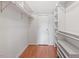 Walk-in closet with white shelving, ample storage space, and hardwood floors at 912 Salem Woods Dr, Raleigh, NC 27615