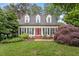Charming home with a manicured lawn, red door, and dormer windows at 912 Salem Woods Dr, Raleigh, NC 27615
