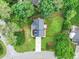 Aerial view of a home surrounded by green trees, a paved driveway, and a well-maintained lawn at 1005 Barmkin Pl, Knightdale, NC 27545