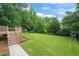 Large, lush backyard accessible from wooden deck and featuring a green, manicured lawn at 1005 Barmkin Pl, Knightdale, NC 27545