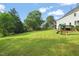 Expansive backyard featuring a large, well-manicured lawn, a play set, and a black metal fence at 1005 Barmkin Pl, Knightdale, NC 27545