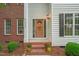 Inviting front entrance showcasing a wood door, brick steps with plants, and decorative accents at 1005 Barmkin Pl, Knightdale, NC 27545