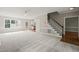 Open-concept living area featuring carpet flooring, a ceiling fan, and staircase at 1005 Barmkin Pl, Knightdale, NC 27545