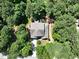 A sprawling home is nestled among dense trees, featuring a well-maintained roof and outdoor seating area at 1009 Blue Larkspur Ave, Wake Forest, NC 27587