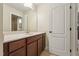 Well-lit bathroom features neutral tiling, a dark wood vanity with white countertop, and white door with black handle at 1009 Blue Larkspur Ave, Wake Forest, NC 27587